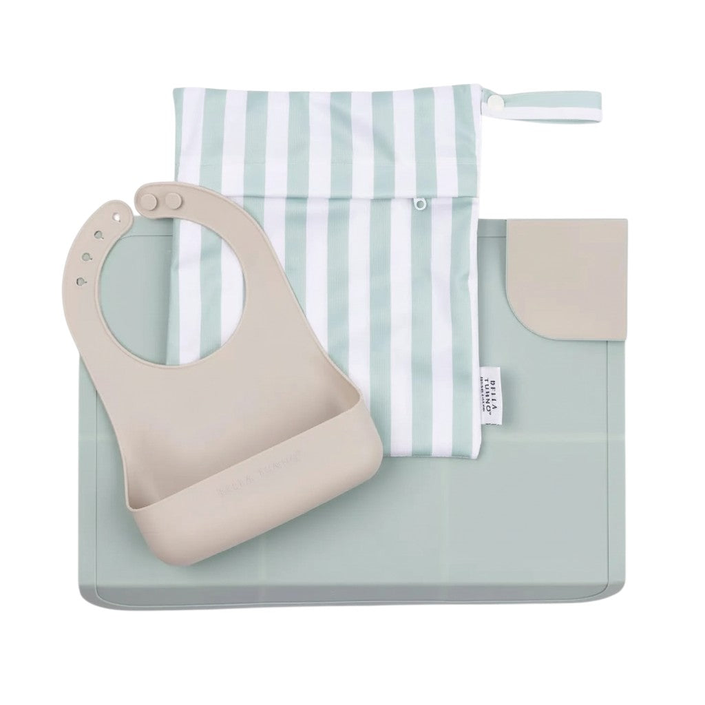 Mom & Me Boutique Pack and Go Bundle in Grassy Field featuring a beige silicone bib, placemat, and striped wet bag.