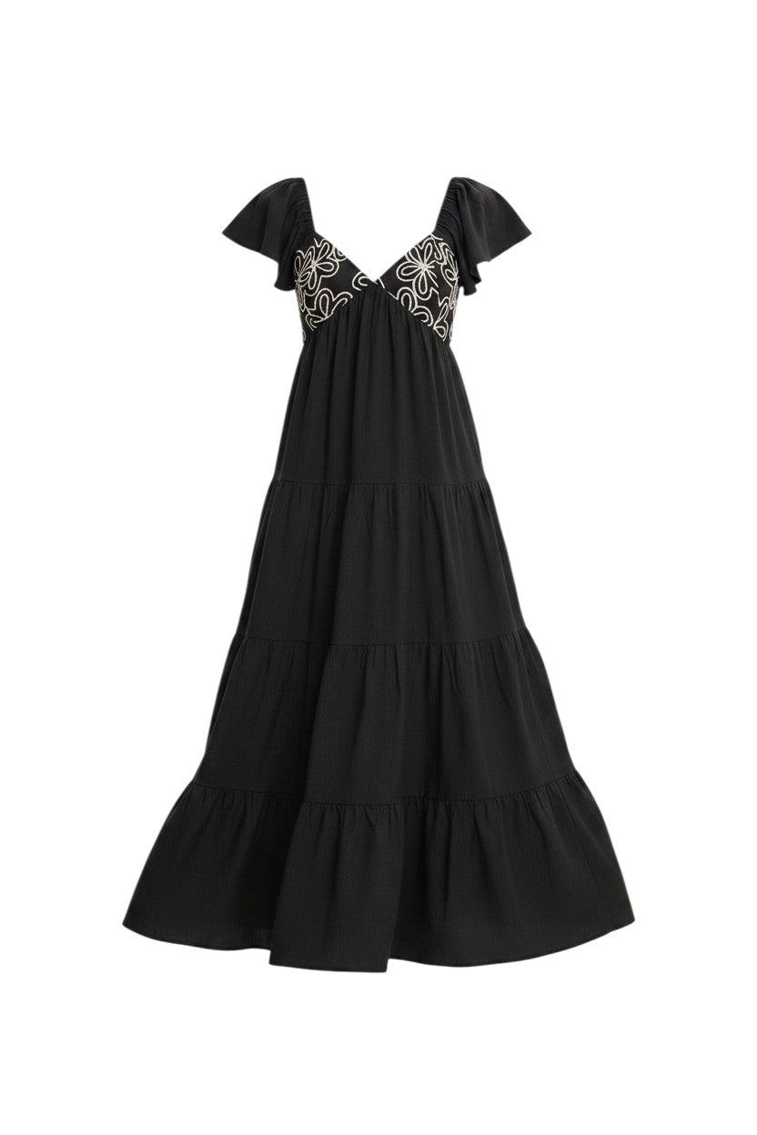 Mom & Me Boutique black maxi dress with deep v-neck, white floral embroidery, flutter sleeves, and tiered ruffles.
