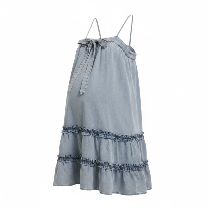 Mom & Me Boutique Harlee denim babydoll mini dress with spaghetti straps, front bow, and tiered ruffled hem.