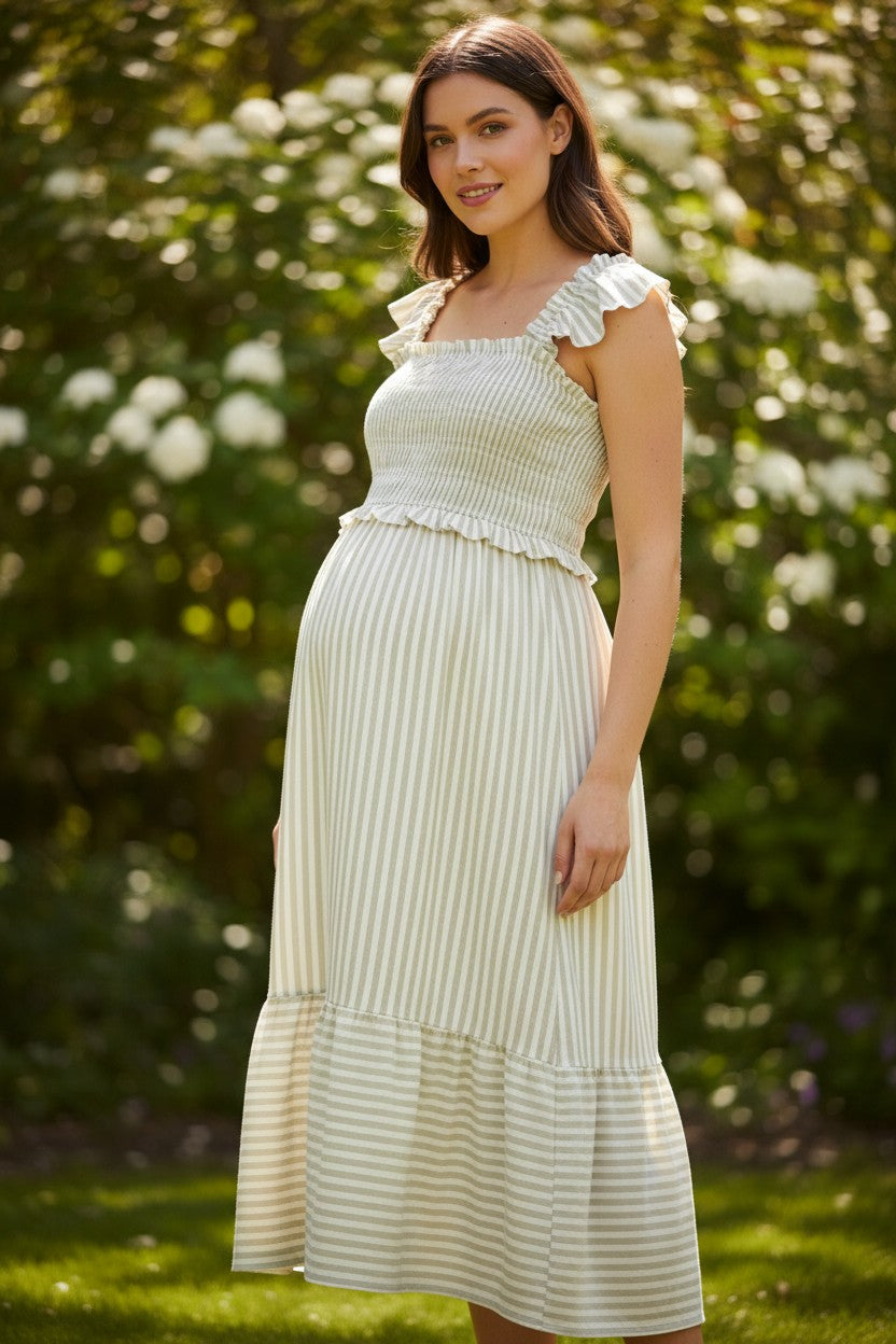 Pregnant woman wearing a Mom & Me Boutique light olive striped midi dress with smocked bodice and ruffle trim
