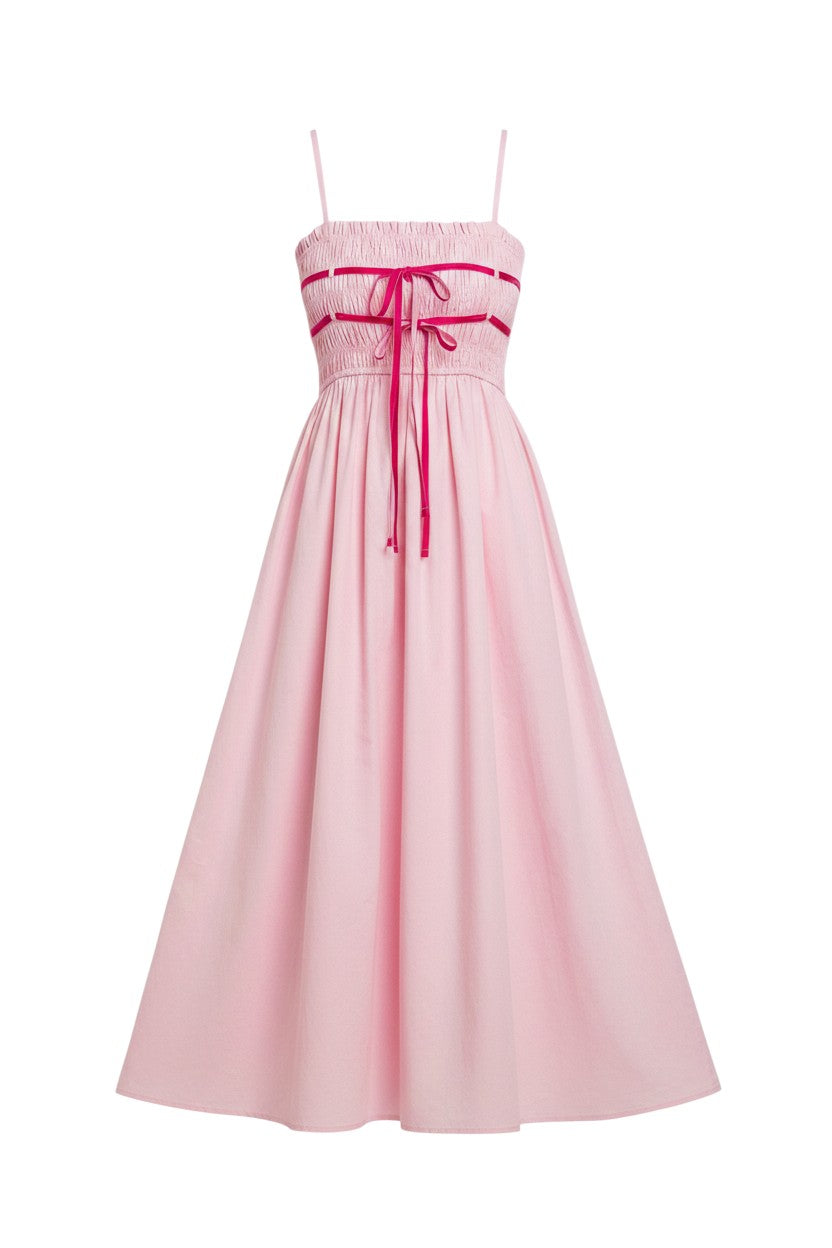 Mom & Me Boutique Daphne midi dress in light pink cotton with spaghetti straps, smocked bodice, and magenta bow detail.