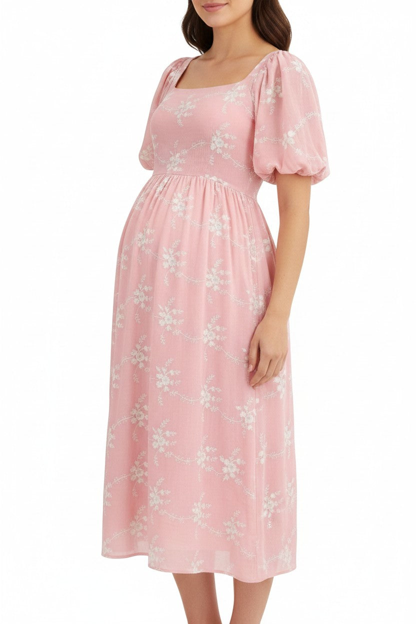 Mom & Me Boutique pink midi dress with white floral embroidery, square neckline, and puff sleeves on a pregnant model
