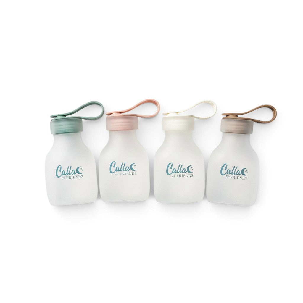 Mom & Me Boutique set of four reusable silicone storage bags in pastel green, pink, white, and brown with loop lids.