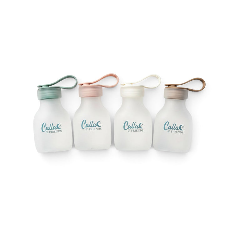 Mom & Me Boutique set of four reusable silicone storage bags in pastel green, pink, white, and brown with loop lids.