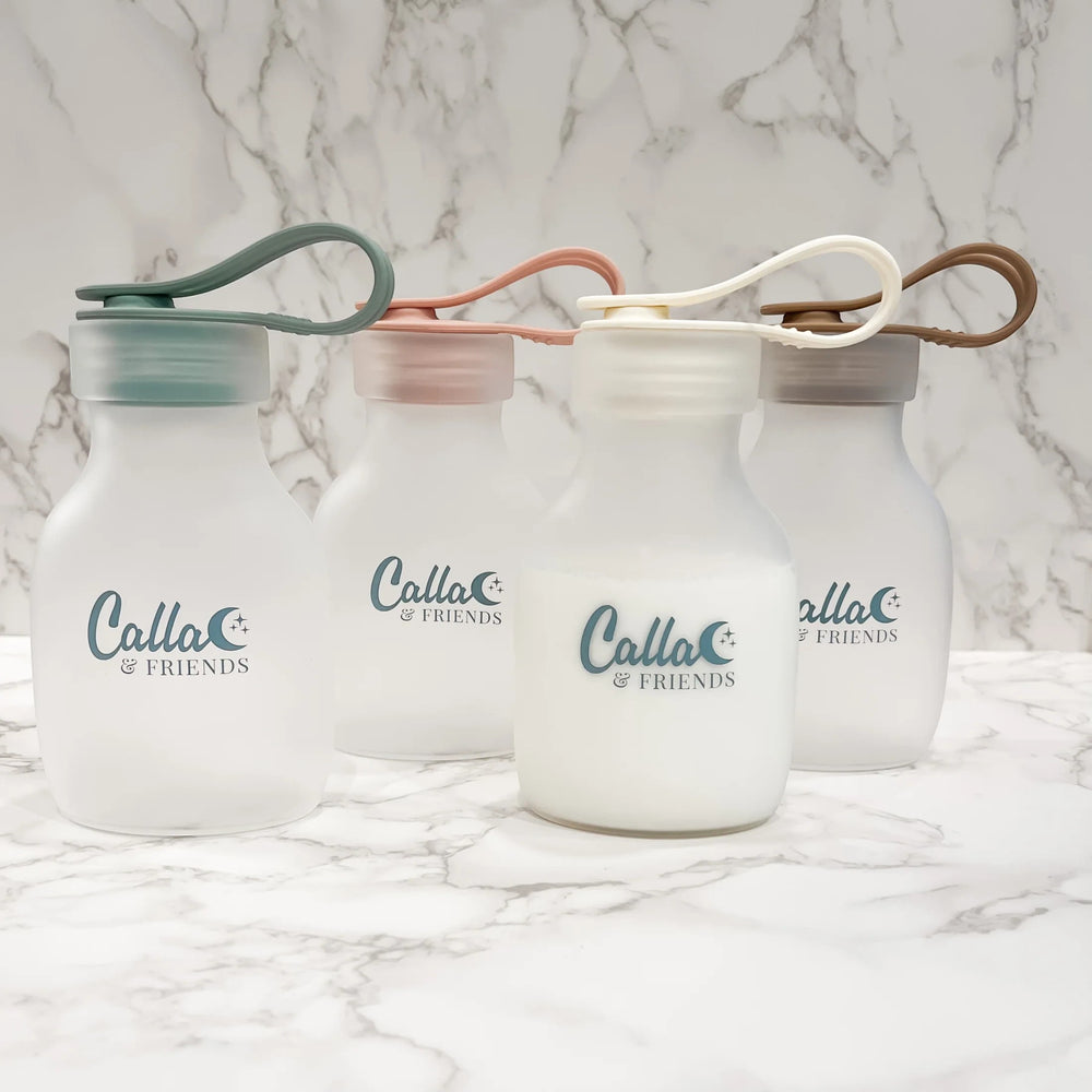 Mom & Me Boutique reusable silicone milk and puree storage bags in four soft pastel colors with leak-proof lids.