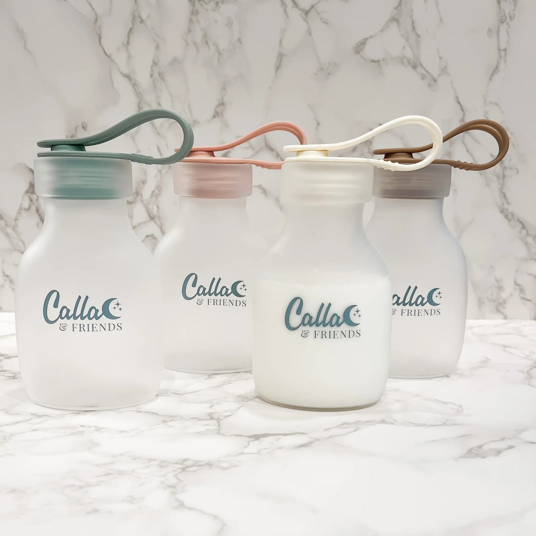 Mom & Me Boutique reusable silicone milk and puree storage bags in four soft pastel colors with leak-proof lids.