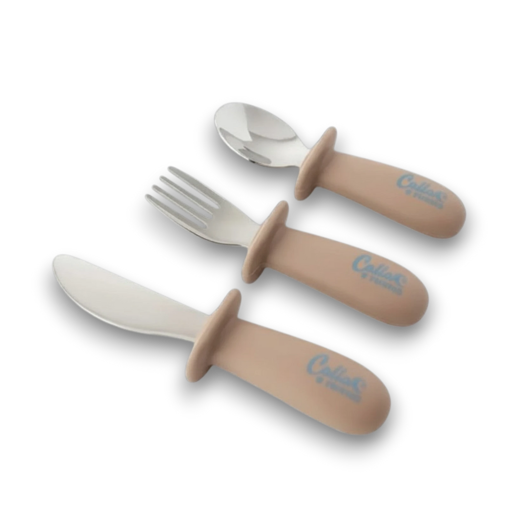 Mom & Me Boutique toddler utensil set with beige silicone handles and stainless steel spoon, fork, and knife.