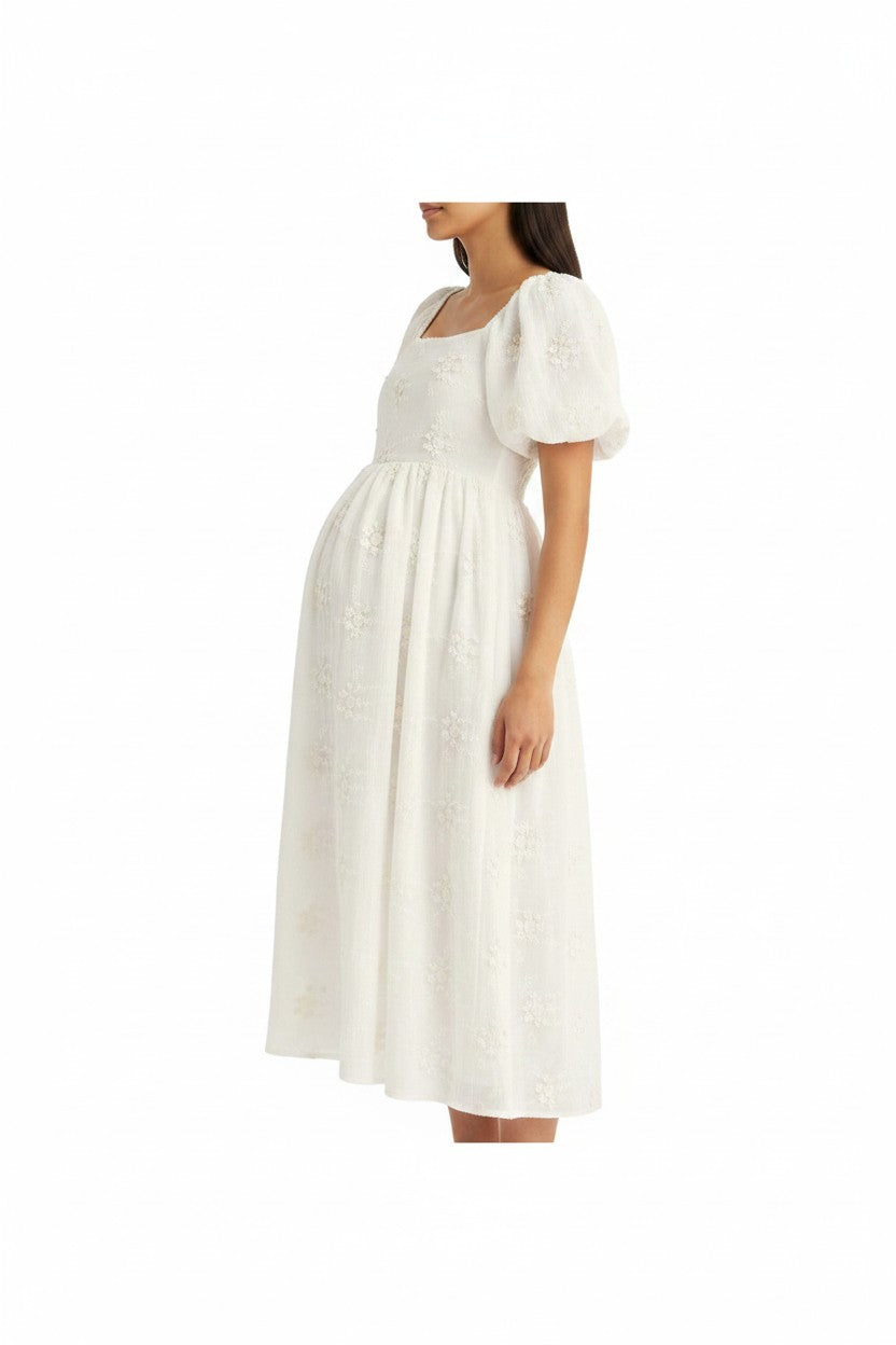Mom & Me Boutique white midi dress with embroidered florals, square neckline, and puff sleeves on a pregnant model.